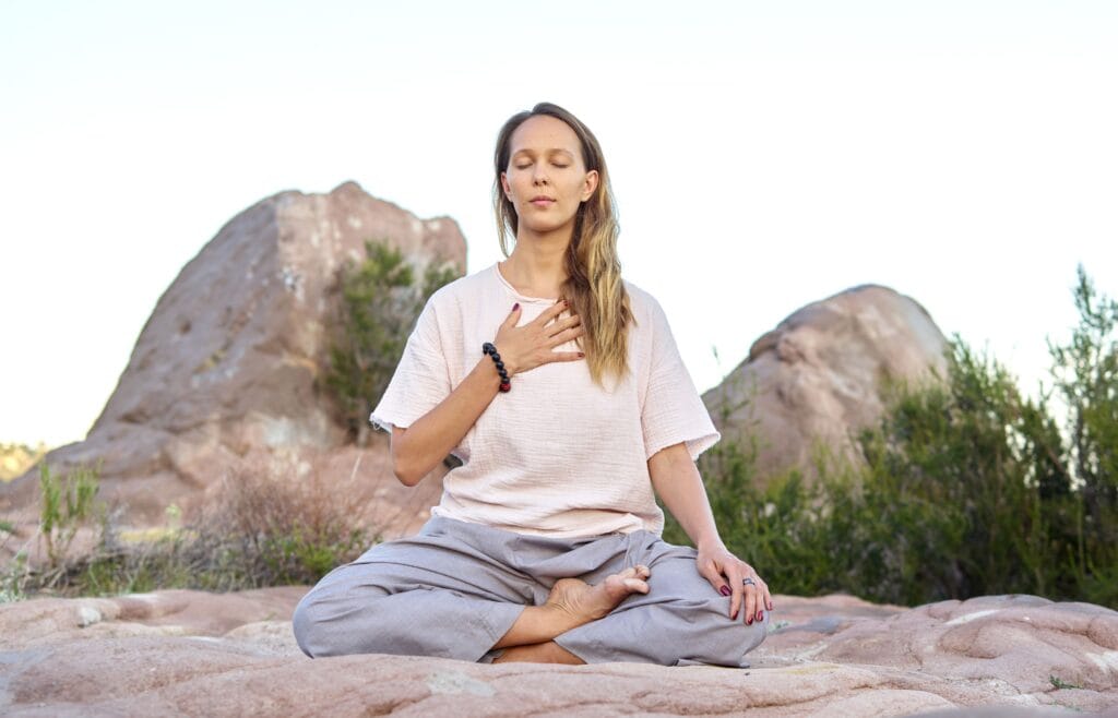 ženska ki meditira na prostem